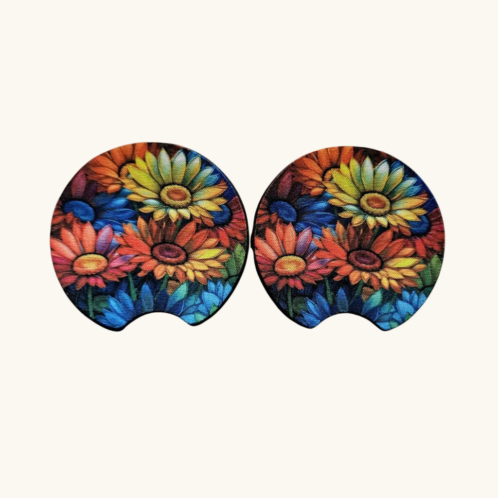 A pair of oval-shaped, contoured ear cushions featuring a vibrant, multicolored floral print of daisies in red, yellow, blue, and orange on a light cream background.